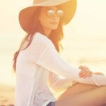 Woman sits in the sun and shows how you can be sun safe using natural sun lotion